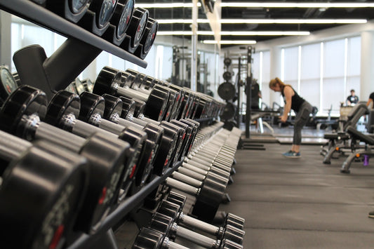 Well-equipped home gym with barbell, rack, and rubber flooring