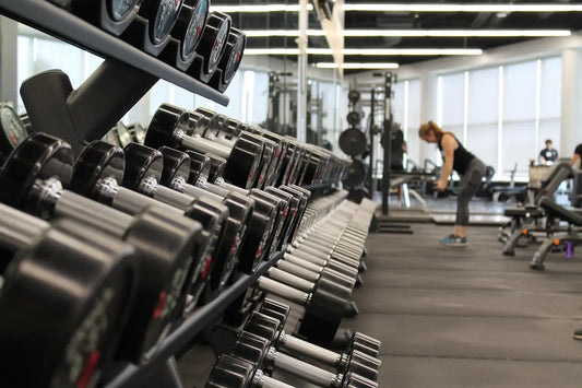 Well-equipped home gym with barbell, rack, and rubber flooring