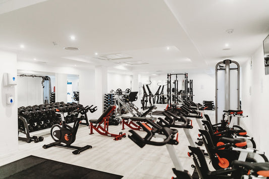Compact home gym setup with kettlebells, pull-up bar, and rubber flooring in a small space