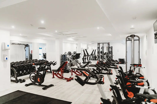 Compact home gym setup with kettlebells, pull-up bar, and rubber flooring in a small space
